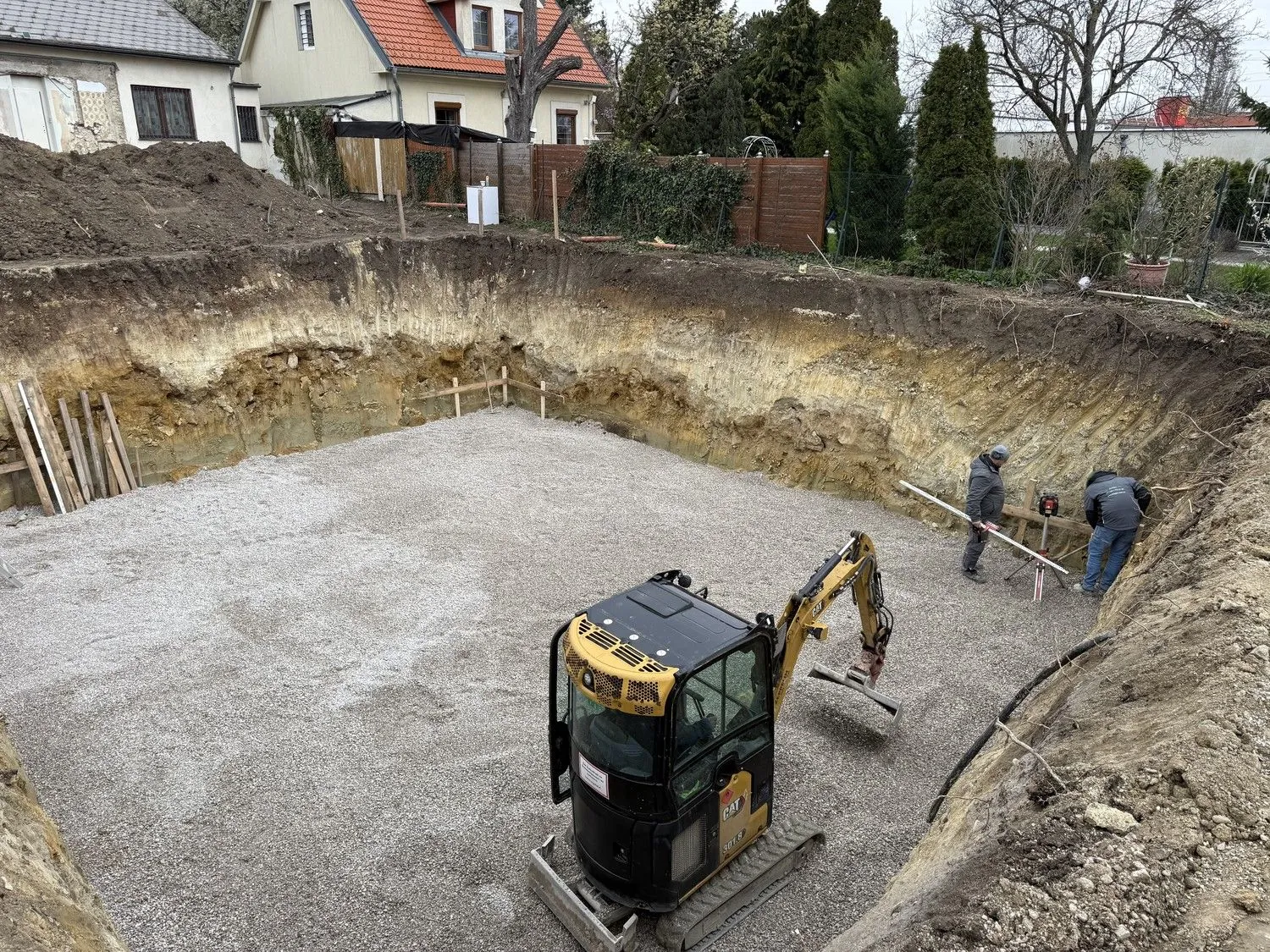 Minibagger in einer Baugrube mit Schotterbett