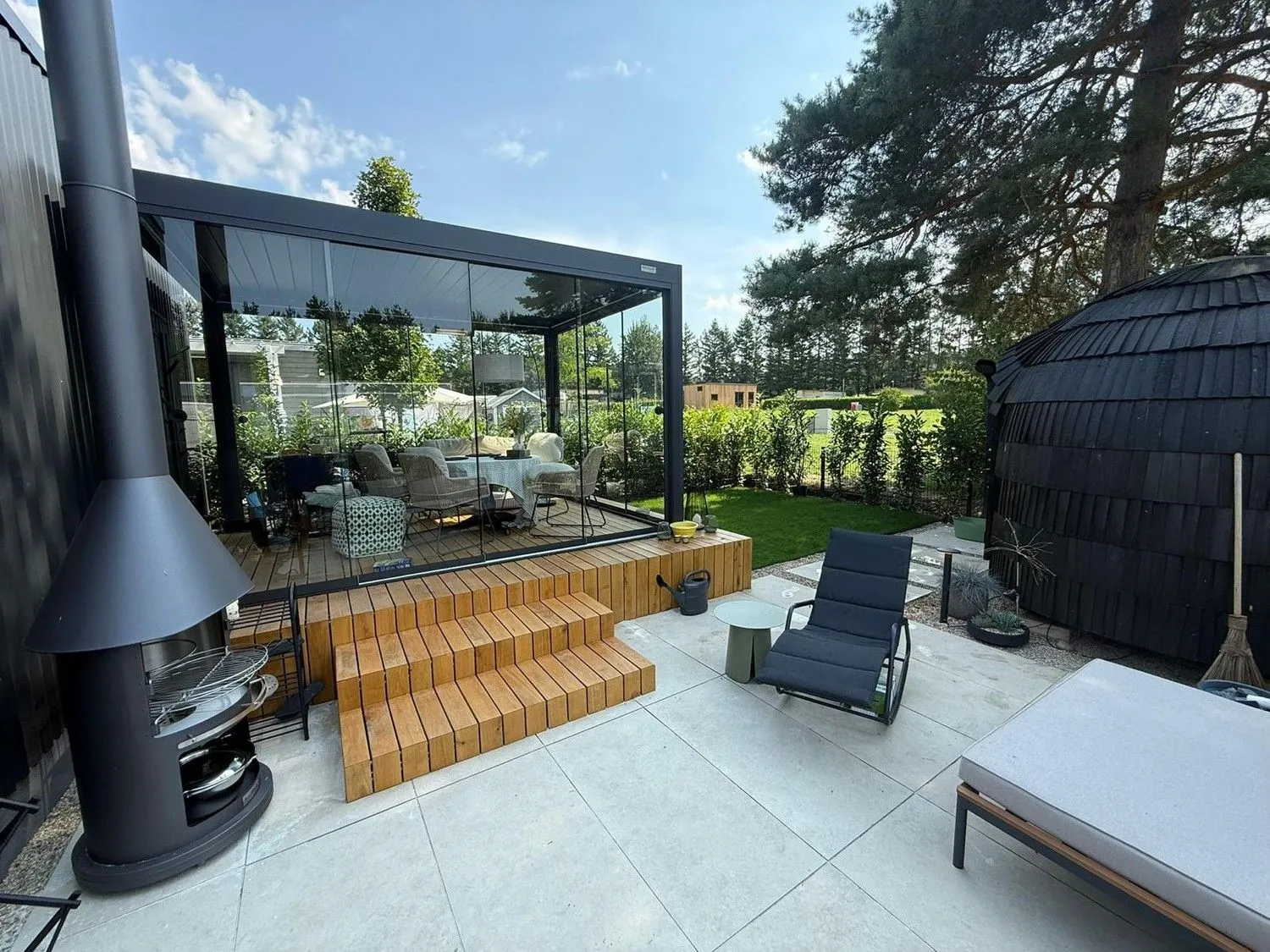 Fertige Terrasse mit Holzstufen, Pergola und Rasen
