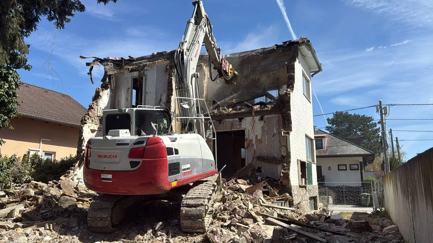 Bagger der EMK beim Abbruch eines alten Hauses
