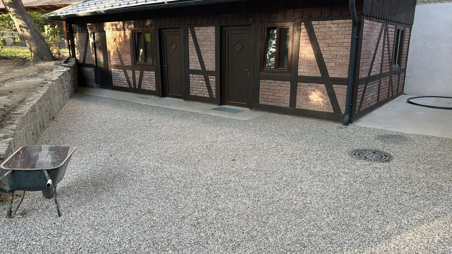 Fertiger Hof mit Kiesbelag vor einem Nebengebäude