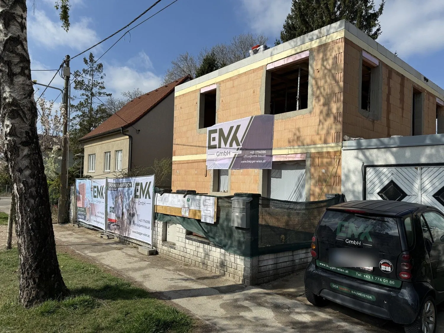 Zweigeschoßiger Rohbau mit EMK-Banner an der Fassade