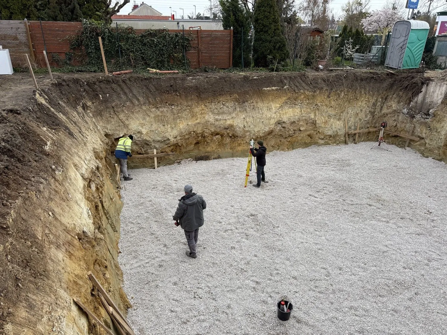 Baugrube mit Schotterbett beim Vermessen